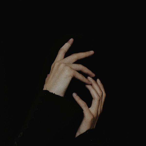 Person in a balanced pose against a dark, minimalist background.